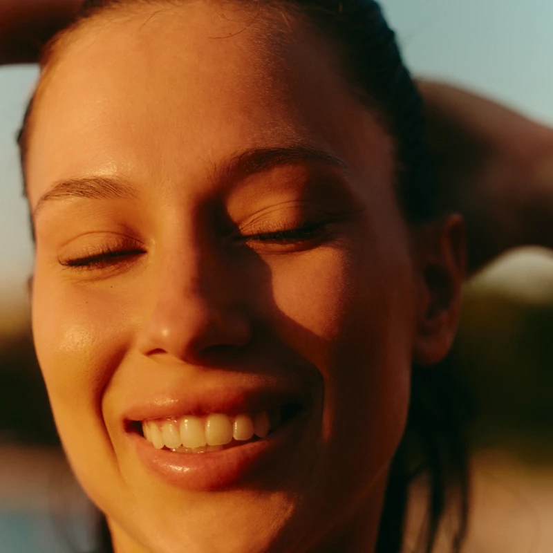 Woman smiling with sunshine